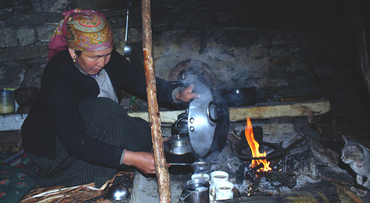 a local woamn making tea during homestay tour in Nepal